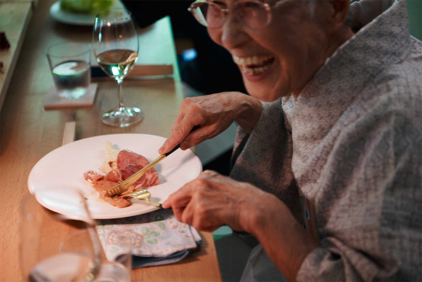笑顔で食事をする高齢女性の画像